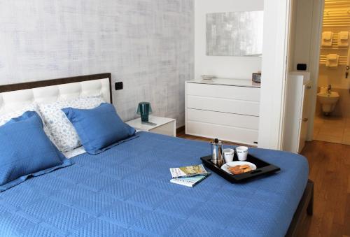 un letto blu con un vassoio di cibo sopra di Perfect apartment Como a Como