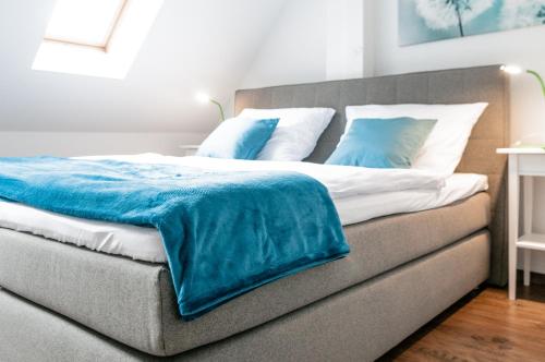 Una cama con una manta azul encima. en Tarata Haus, en Halle an der Saale