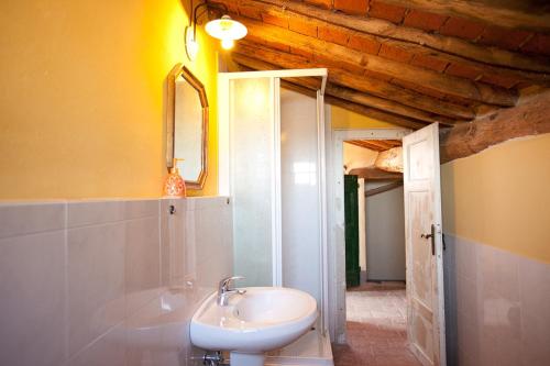 y baño con lavabo blanco y espejo. en Borgo Fajani, en Terricciola