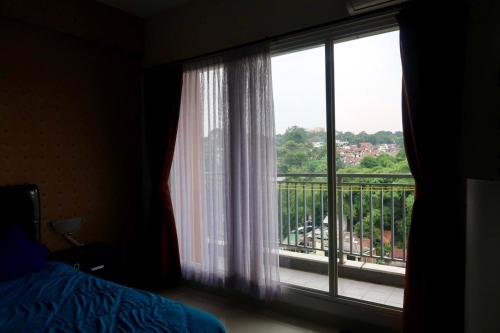 a bedroom with a window with a view of a city at Bacup Studio Apartment @Galeri Ciumbuleuit in Bandung