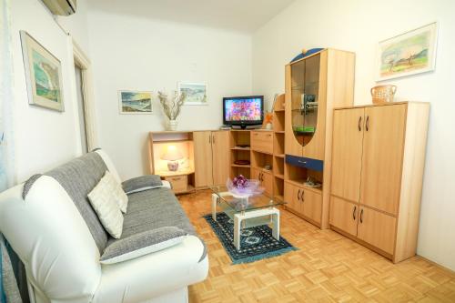 a living room with a couch and a tv at Apartments Pyros in Piran