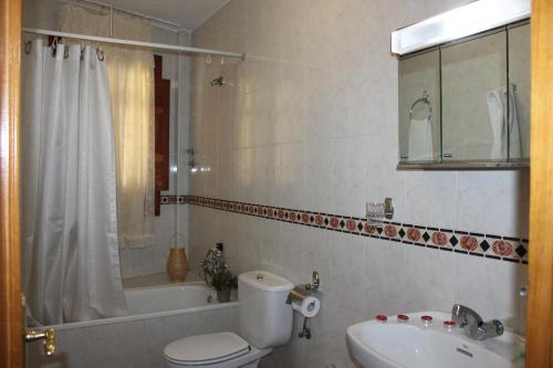a bathroom with a toilet and a sink and a tub at Apartamentos Rurales Rosendo: El Celindo in Capileira