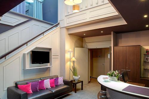 ニオールにあるベスト ウエスタン ホテル ドゥ ラ ブレッシュのリビングルーム(ピンクの枕とソファ付)
