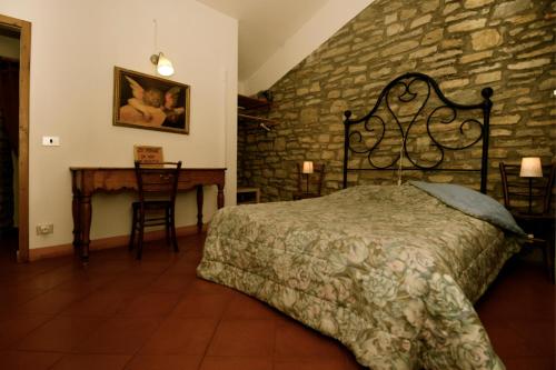 1 dormitorio con cama y pared de piedra en B&B Luna e Stelle, en Premilcuore