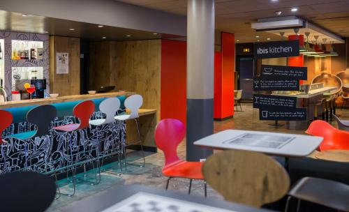 a restaurant with colorful chairs and a counter at ibis Toulouse Centre in Toulouse