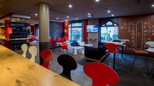 a restaurant with red chairs and a table in a room at ibis Toulouse Centre in Toulouse