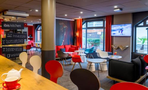 a restaurant with colorful chairs and tables and a bar at ibis Toulouse Centre in Toulouse