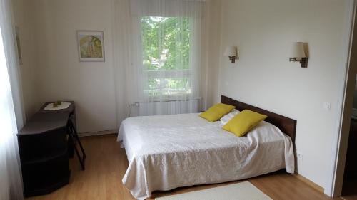 1 dormitorio con 1 cama con 2 almohadas amarillas en Ribere Apartment, en Pärnu