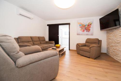 a living room with two couches and a tv at Hacienda Nikolic in Milna
