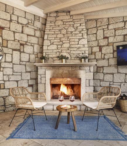 two chairs and a table in front of a stone fireplace at Alachi Hotel in Alacati