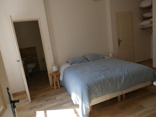 a bedroom with a bed and a bathroom with a toilet at La demeure d'Aiglepierre in Aiglepierre