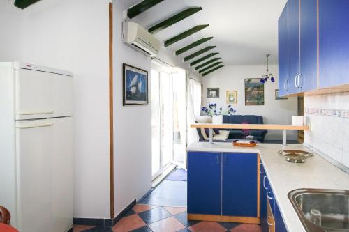 a kitchen with blue cabinets and a blue refrigerator at Apartment Ida in Trpanj