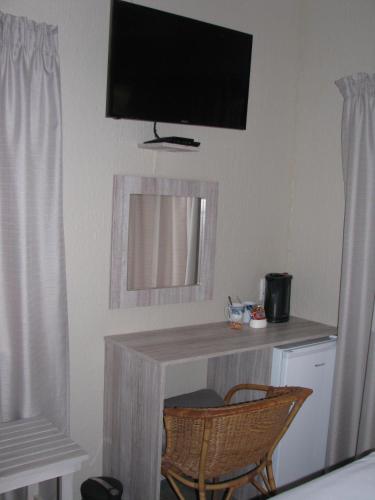 a room with a desk with a television on the wall at Kruger's Guest House in White River