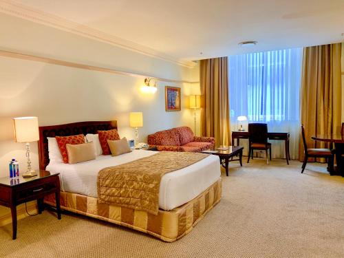 a hotel room with a bed and a living room at Royal Albert Hotel in Brisbane