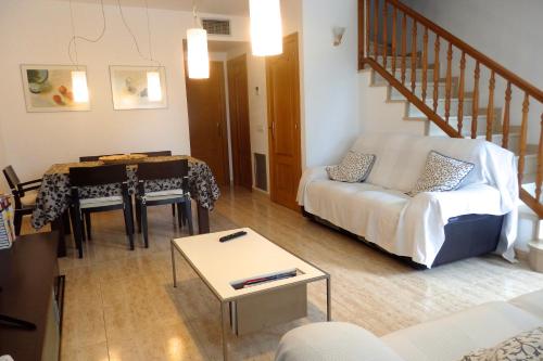 a living room with a white couch and a table at MEDDAYS CHALET EUCALIPTUS 6 in Miami Platja