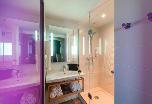 a purple bathroom with a sink and a shower at ibis Styles Les Sables Olonne in Les Sables-dʼOlonne