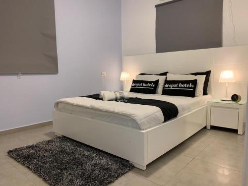 a white bedroom with a large white bed with pillows at Spat Apartments in Bat Yam