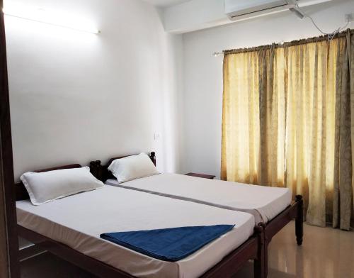 a bed in a room with a window at Honey Bee Serviced Apartments Trivandrum in Trivandrum