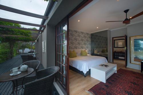 a bedroom with a bed and a balcony at Kanonkop House in Knysna