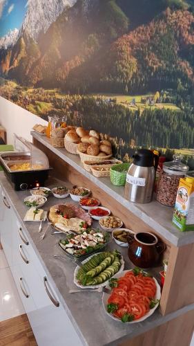 a buffet with many plates of food on a counter at Villa Cicho Sza in Czarna Góra
