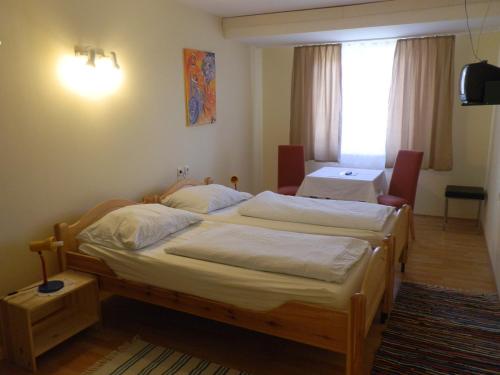 アイゼンシュタットにあるGasthof Wimmerのベッド2台とテーブルが備わるホテルルームです。