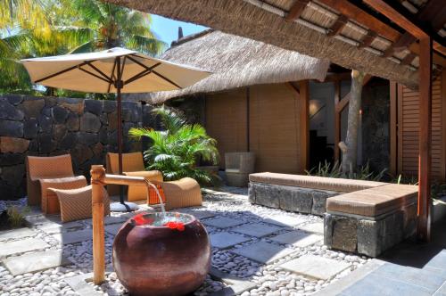 a patio with an umbrella and a table and chairs at Coin de Mire Attitude in Cap Malheureux