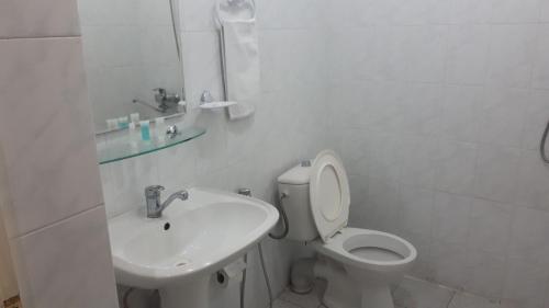 ein weißes Bad mit einem WC und einem Waschbecken in der Unterkunft AZPETROL HOTEL GAZAX in Qazax