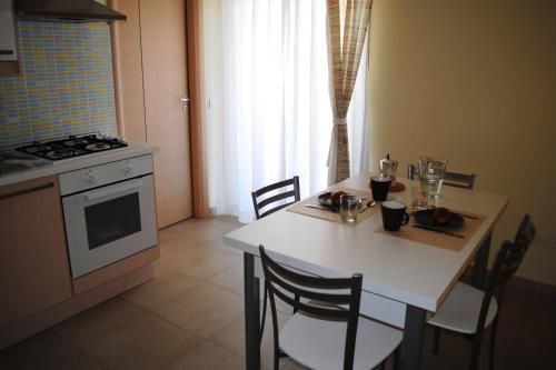 a kitchen with a table with chairs and a stove at Residence Demetra in Gela