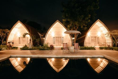 a house with a swimming pool at night at La Roja Bungalows in Nusa Penida