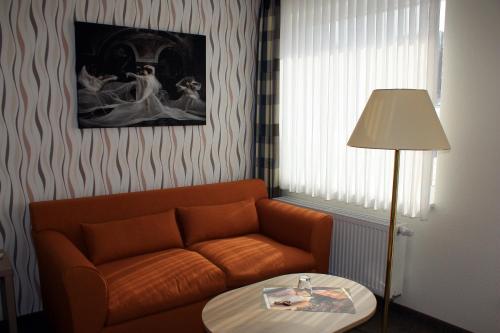 a living room with a couch and a table at Hotel Quellenhof in Salzgitter