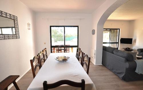 a dining room with a table and a couch at E&M Beach House Aldeamento do Levante III in Porches