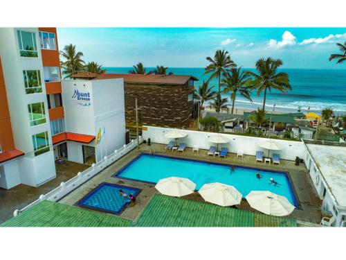 a view of a hotel with a swimming pool and the ocean at Mount Breeze Hotel in Mount Lavinia