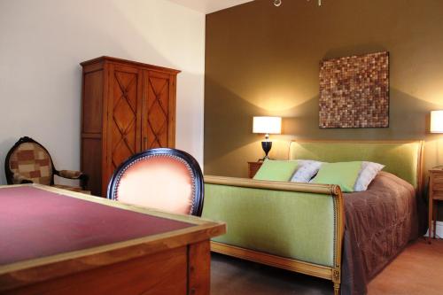 a bedroom with a bed and a table and a chair at Résidence et Chambres d'Hôtes de La Porte d'Arras in Douai