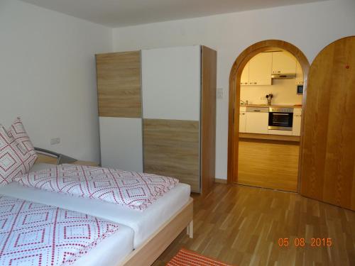 1 dormitorio con 1 cama y cocina en el fondo en Ferienwohnungen Resch en Eckberg