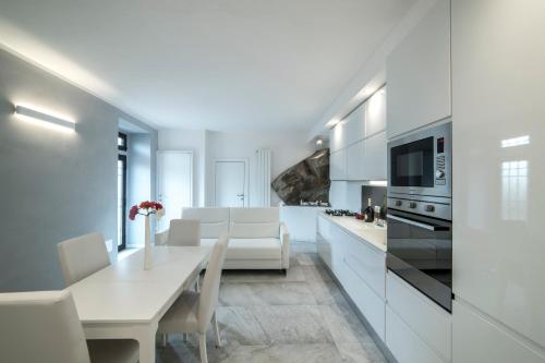 a white kitchen with a white table and chairs at Rocca Palazzaccio in Impruneta
