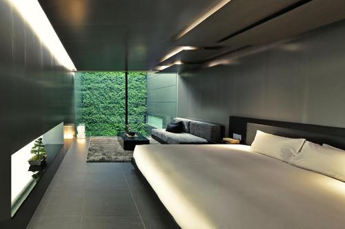 a bedroom with a large white bed and a couch at MOGANA in Kyoto