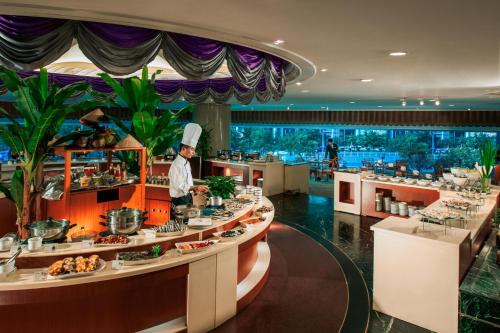 a chef standing in front of a buffet in a restaurant at Shenzhen Sunshine Hotel, Luohu in Shenzhen