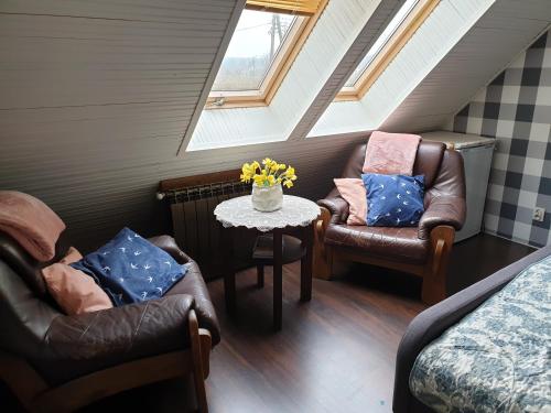 a attic room with two chairs and a table at DOM GOŚCINNY PTASZARNIA - NATURA-Free PARKING in Świnoujście