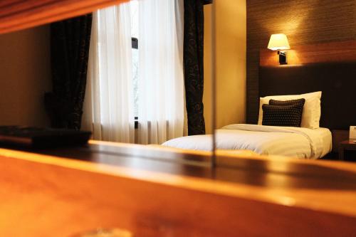 a hotel room with a bed and a window at Best Western Garfield House Hotel in Chryston