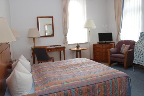 a hotel room with a bed and a television at Weinkeller Wölk in Naumburg