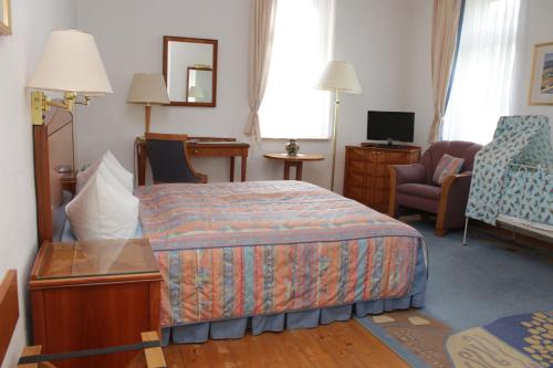 a hotel room with a bed and a chair at Weinkeller Wölk in Naumburg