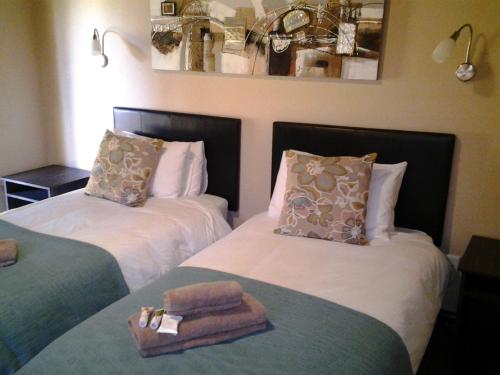 two beds with towels on them in a room at Jock of the Bushveld in Barberton
