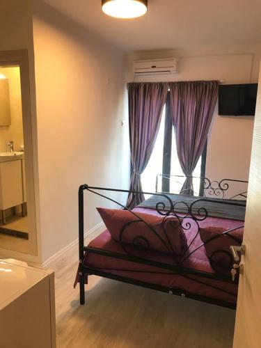 a bedroom with a bed with purple curtains and a window at Rooms Milena in Senj