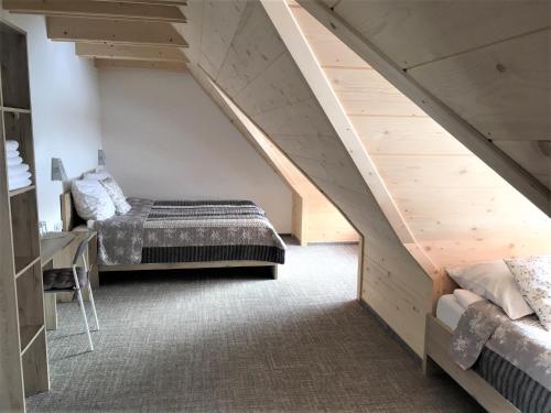 a attic bedroom with a bed and a staircase at Stachelisko - domki i pokoje in Chochołów