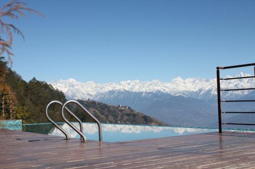 a wooden deck with a view of the mountains at Hotel Mystic Mountain in Nagarkot