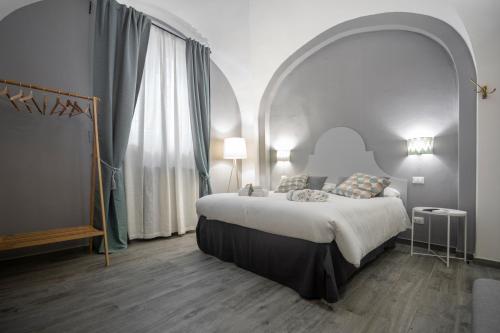 a bedroom with a large bed and an arched window at La Lu cozy rooms in Pisa
