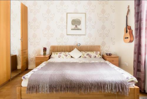 a bedroom with a large bed and a guitar at Charming Central Apartments in Baden-Baden