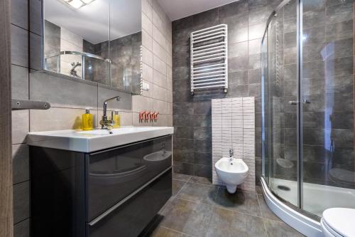 a bathroom with a sink and a shower and a toilet at RentPlanet - Apartament Cicha in Świeradów-Zdrój