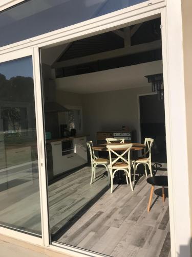 a sliding glass door of a patio with a table and chairs at Maébrilu Camargue Provence in Salin-de-Giraud