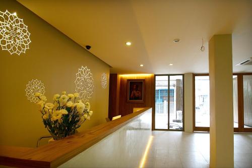 a hallway with a vase of flowers on the wall at CHERN Bangkok in Bangkok